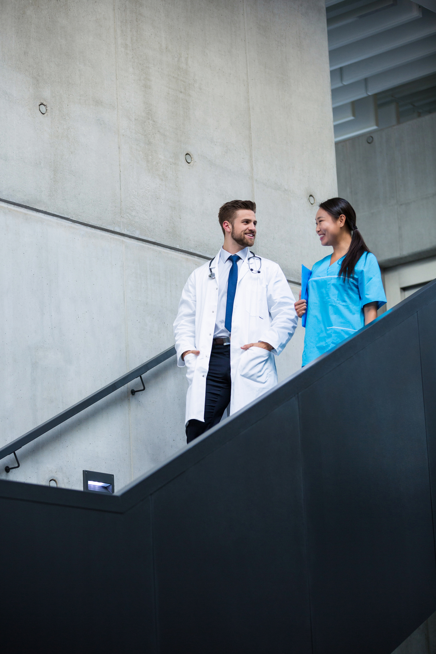 A doctor and nurse walk down stairs